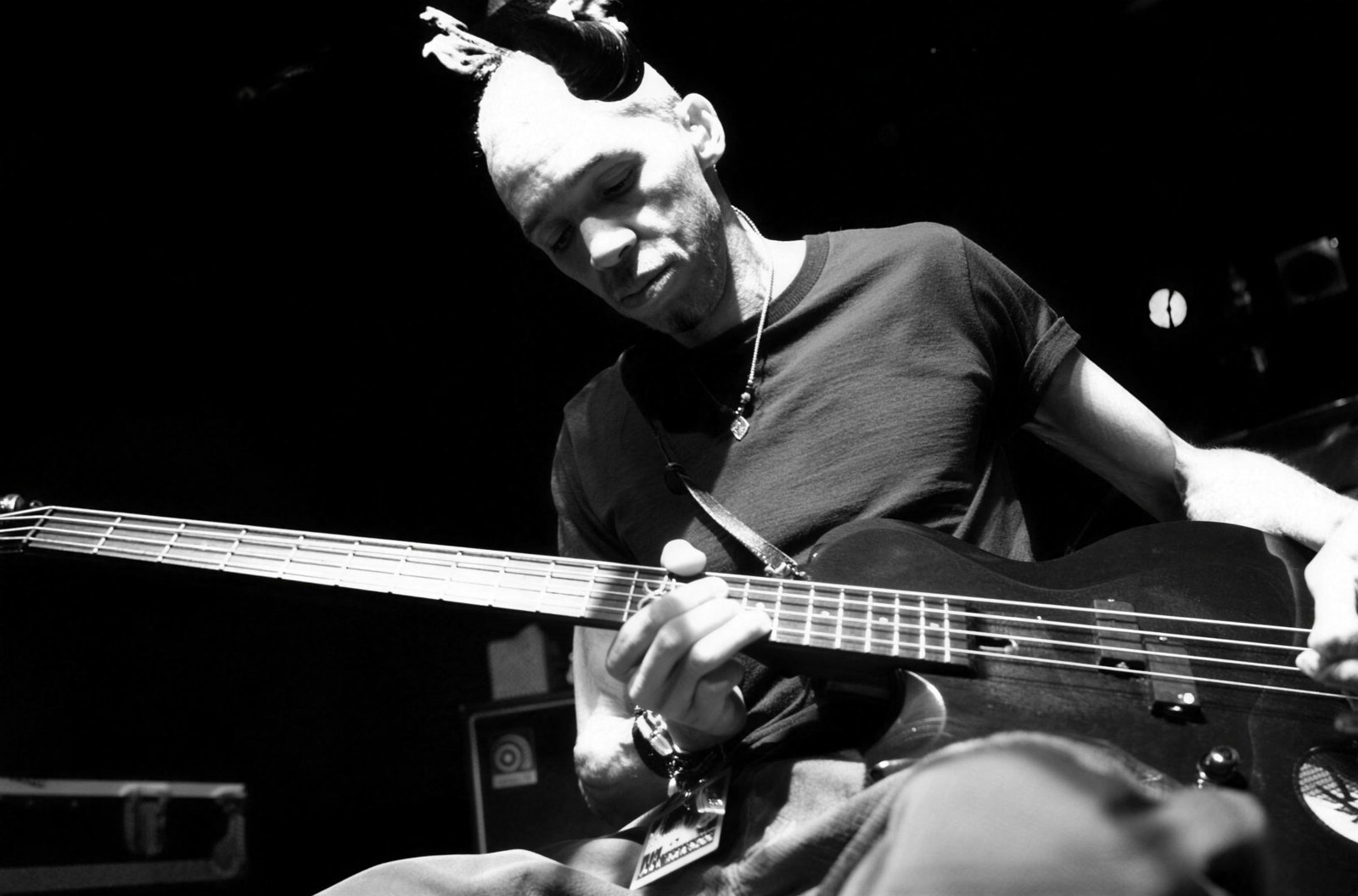 Doug Pinnick of King's X playing bass live on stage, black and white promotional photo