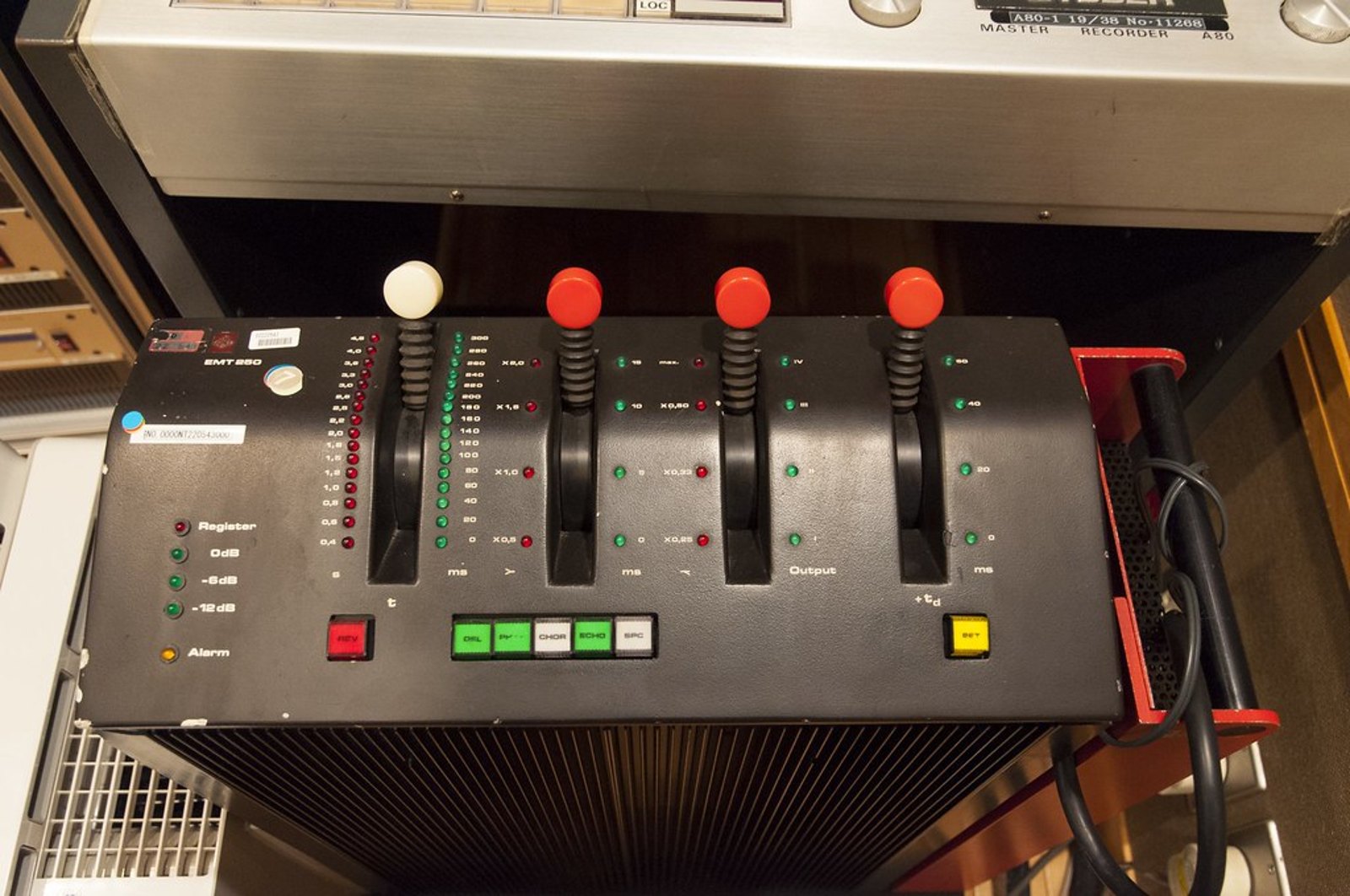 An EMT 250 digital reverb unit mounted directly under a Studer A80 tape machine in a studio rack