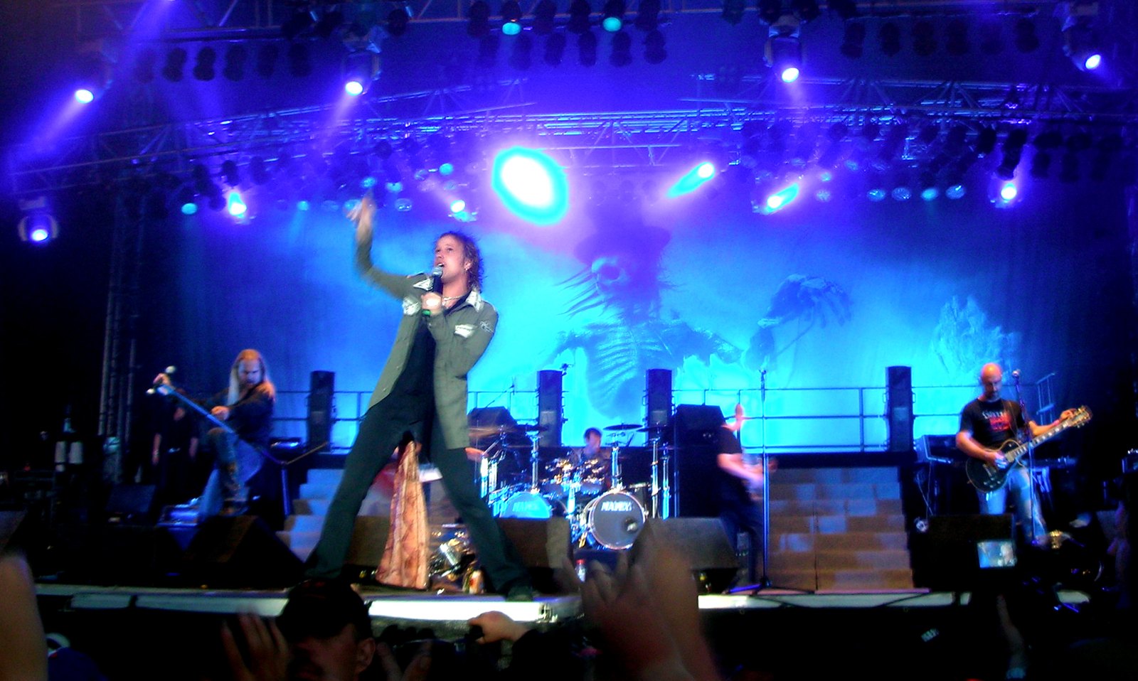 Avantasia at the Sweden Rock Festival in 2008: frontman Tobias Sammet at centre stage, microphone in one hand and the other arm raised, with a guitarist and the rest of the band playing behind him.
