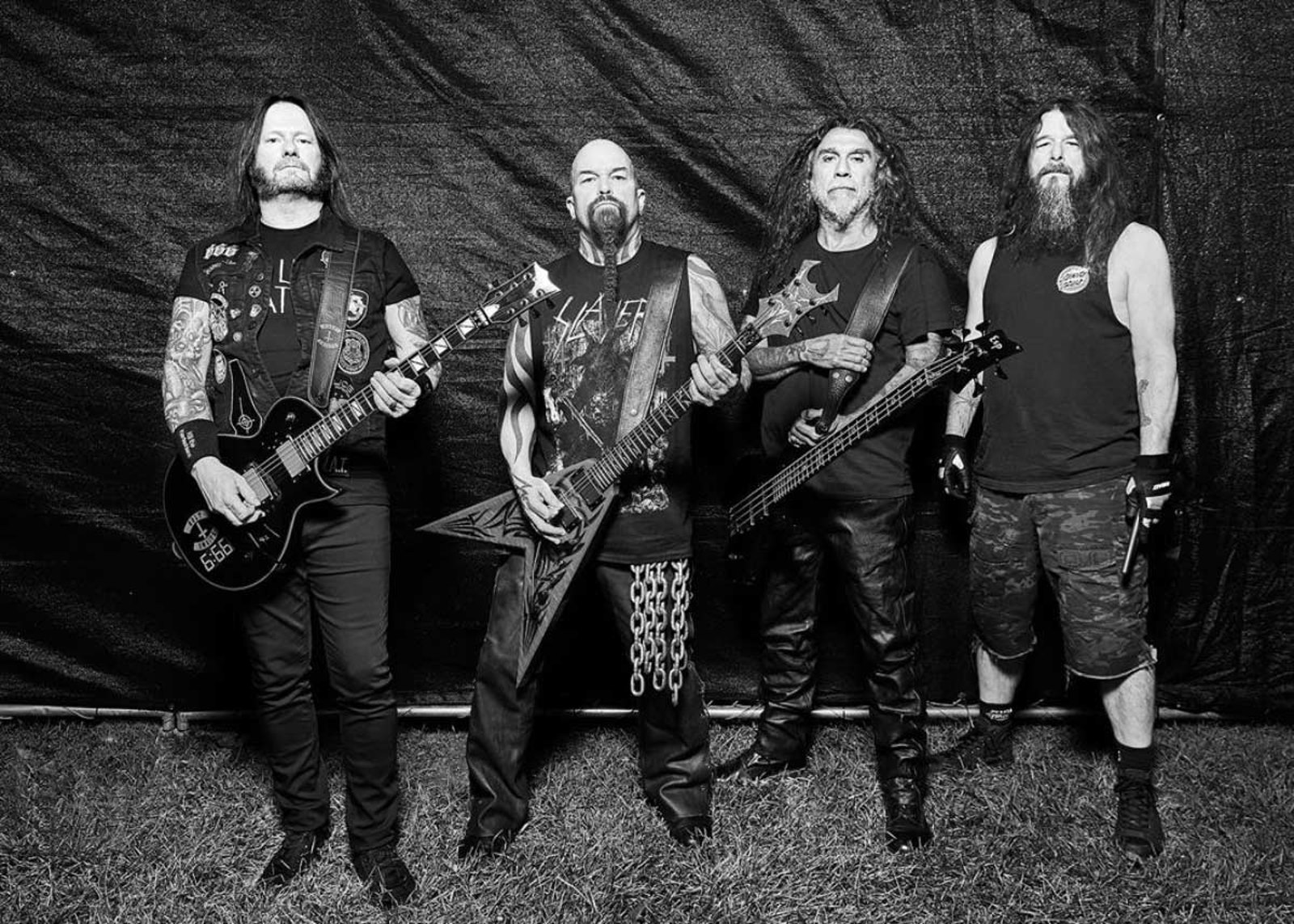 Slayer photographed with their instruments against a black backdrop in 2025