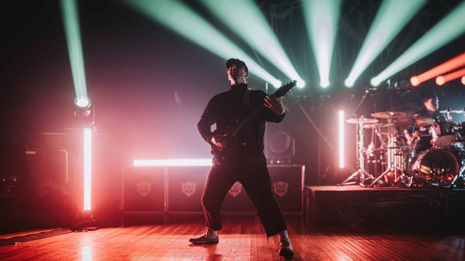 A Chelsea Grin guitarist at centre stage under fans of green and red beam lights and vertical LED bars at The Palladium, Worcester, April 2025.
