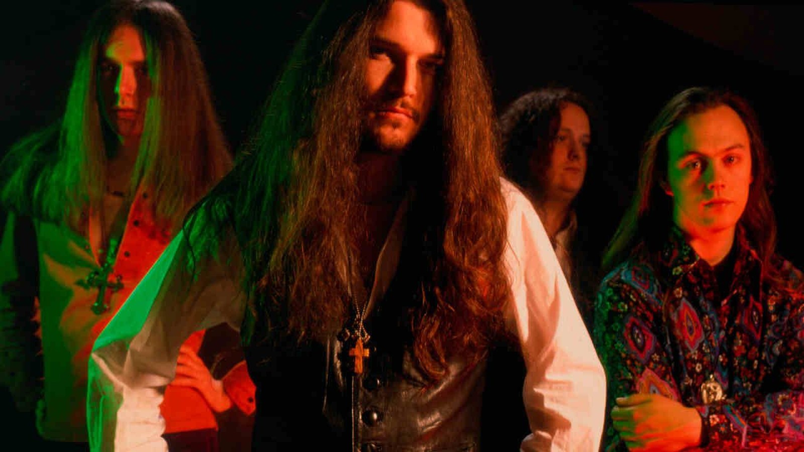 Cathedral, four long-haired musicians in shirts and a leather waistcoat, photographed against a dark background in the early 1990s
