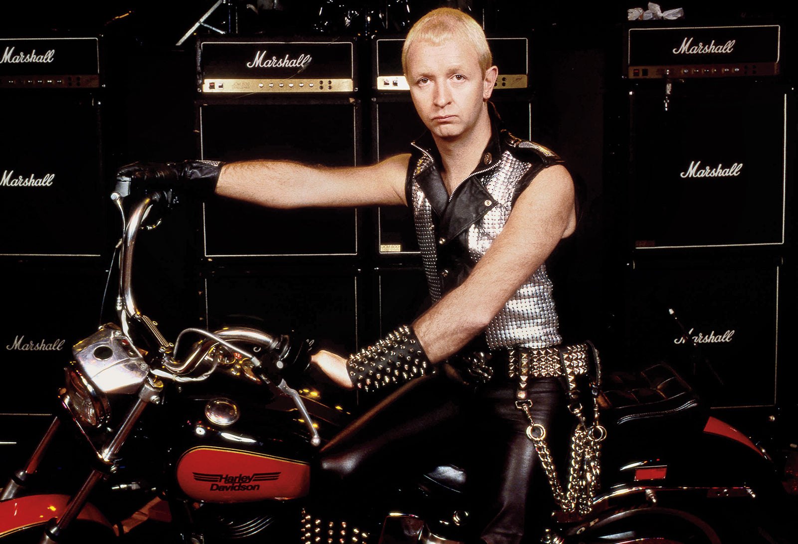 Rob Halford of Judas Priest astride a Harley-Davidson in front of a wall of Marshall cabinets