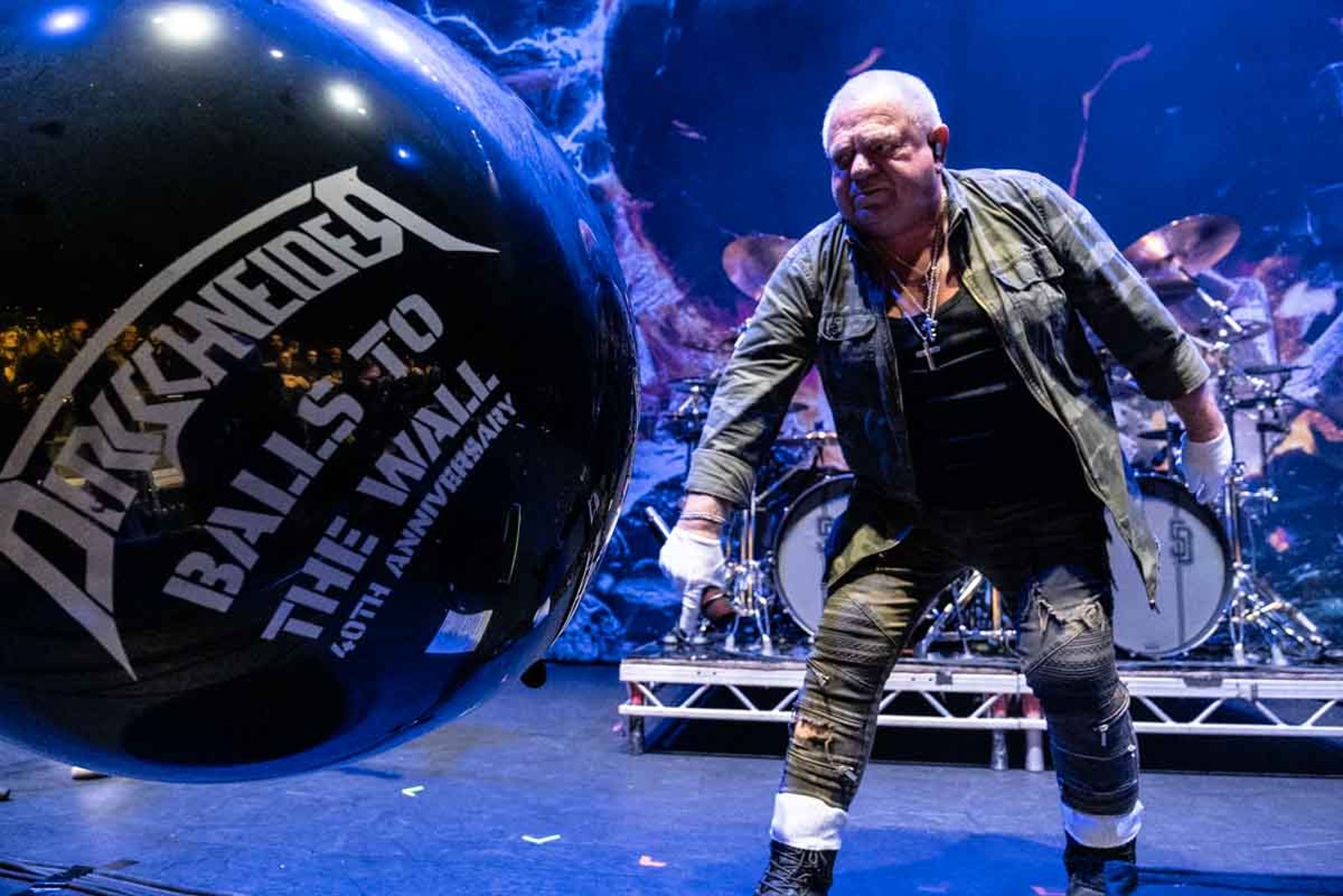Udo Dirkschneider on stage at the Eventim Apollo in London in November 2025, beside a giant ball marking forty years of Balls to the Wall