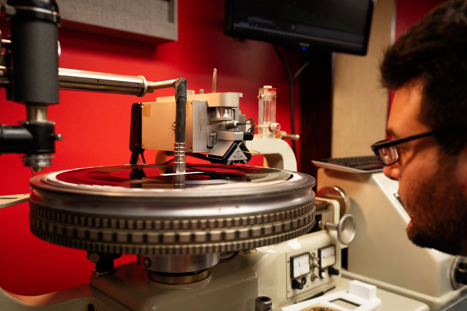 An engineer watching a lacquer disc being cut on a Neumann lathe at a mastering room in Nashville