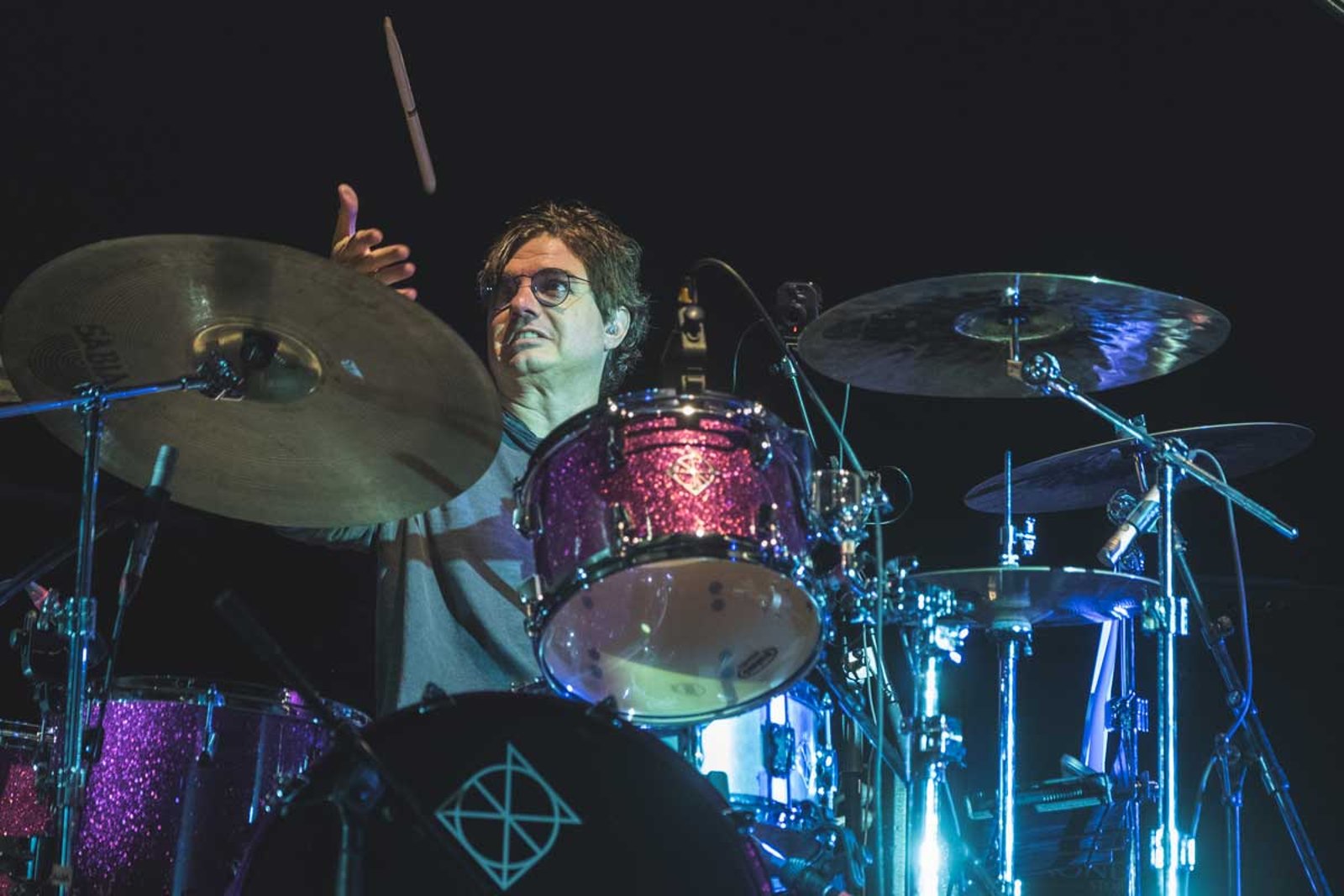 Jules Radino of Blue Oyster Cult behind the kit in Glasgow in 2022, the hook and cross painted on the bass drum head