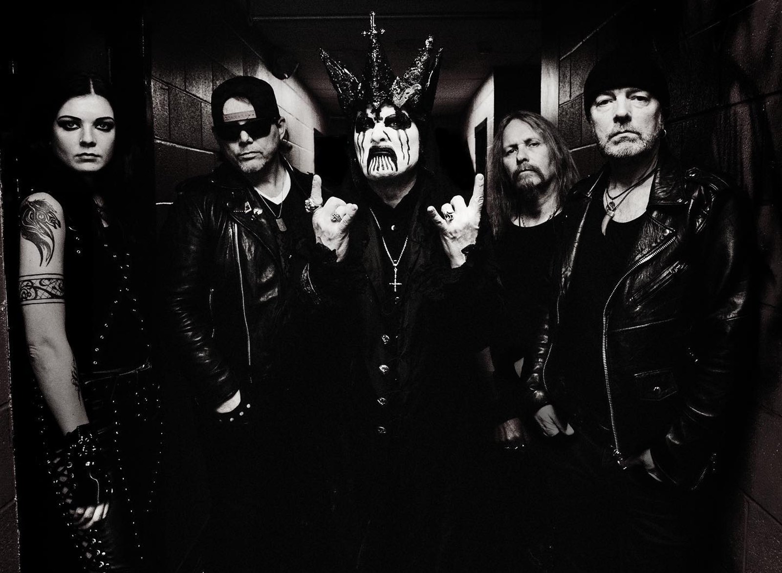 Mercyful Fate posing together in a backstage corridor, King Diamond in his spiked crown and painted face