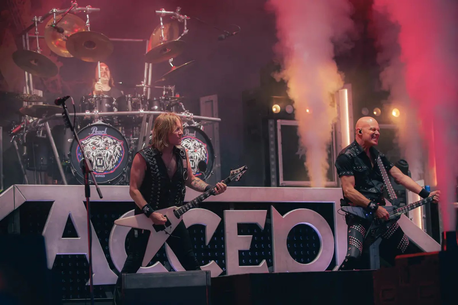 Accept on stage at Stonedead Festival in August 2026, two guitarists behind a lit stage sign carrying the band name