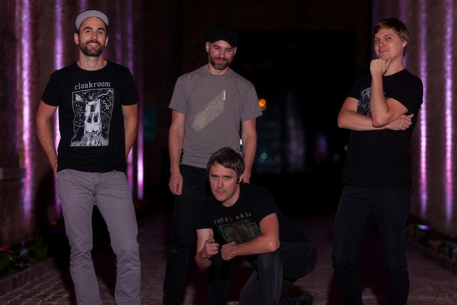 Pelican, the instrumental post-metal band, posed together outdoors at night under purple stage lighting