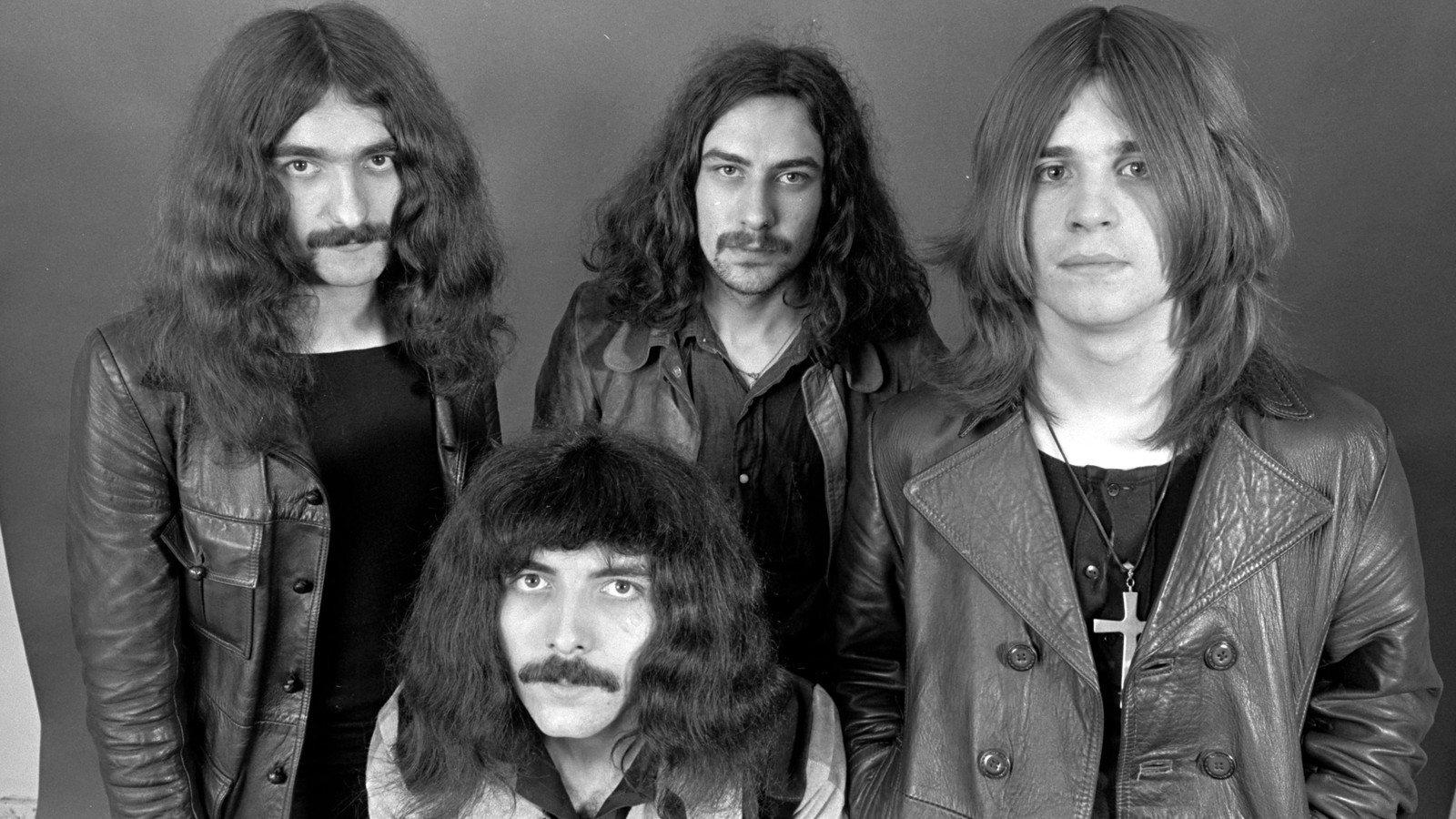 Black Sabbath in 1970, the four original members in leather jackets in a black and white studio portrait
