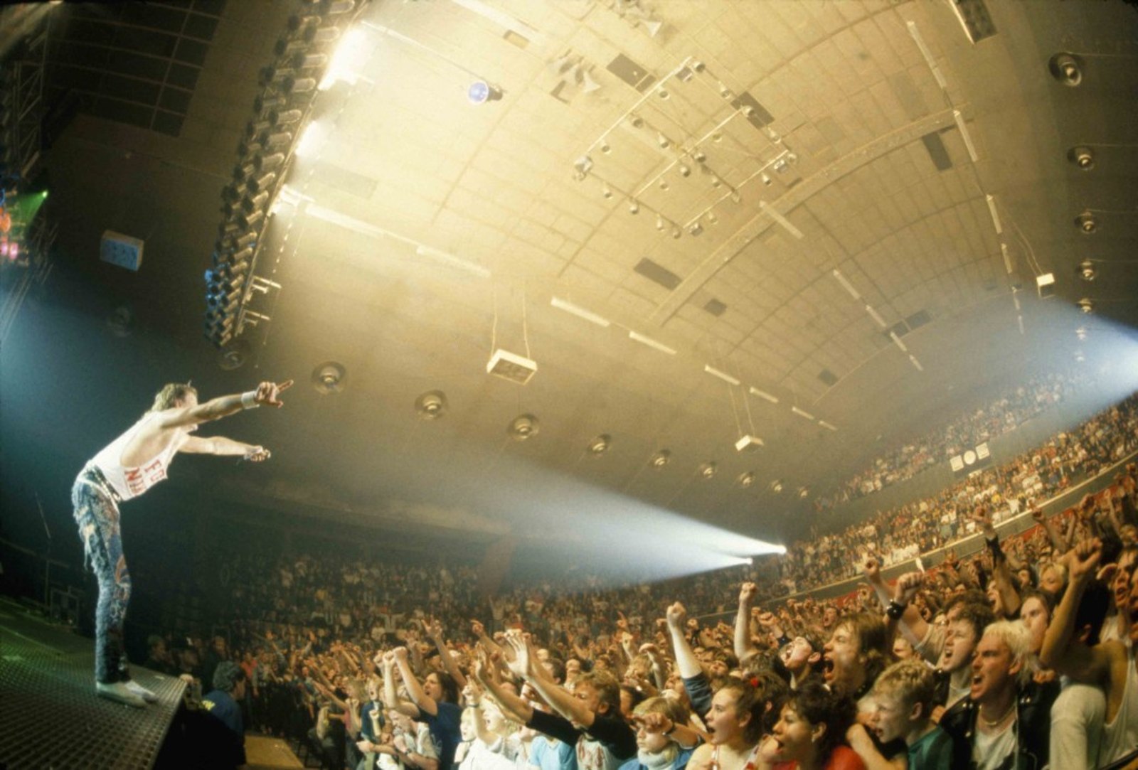 Joe Elliott of Def Leppard pointing out into a packed arena on the Hysteria tour in 1987