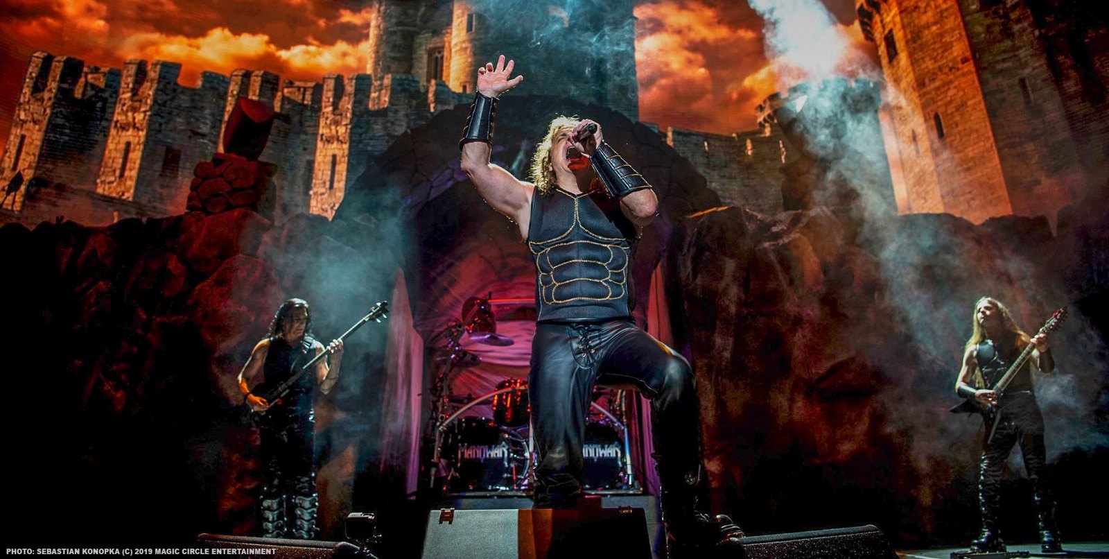Manowar's Eric Adams singing live, flanked by the band on the Kings of Metal MMXIV tour, 2019