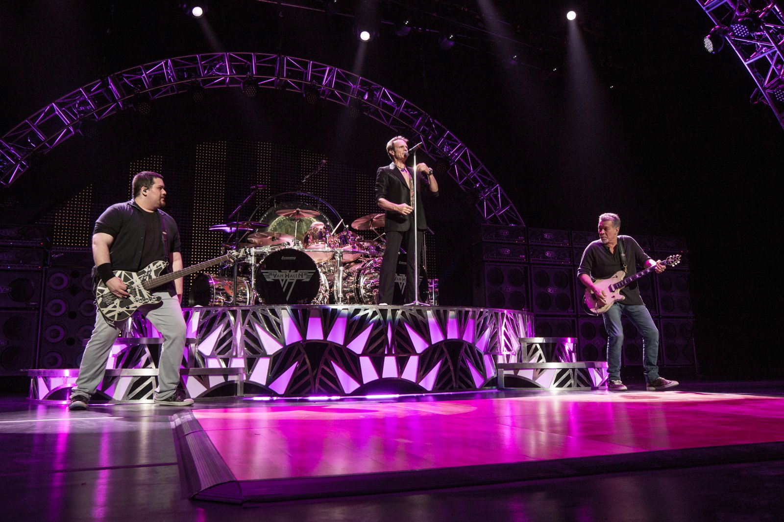Van Halen on stage in 2015, David Lee Roth at the microphone with Eddie Van Halen to his left and Wolfgang Van Halen on bass