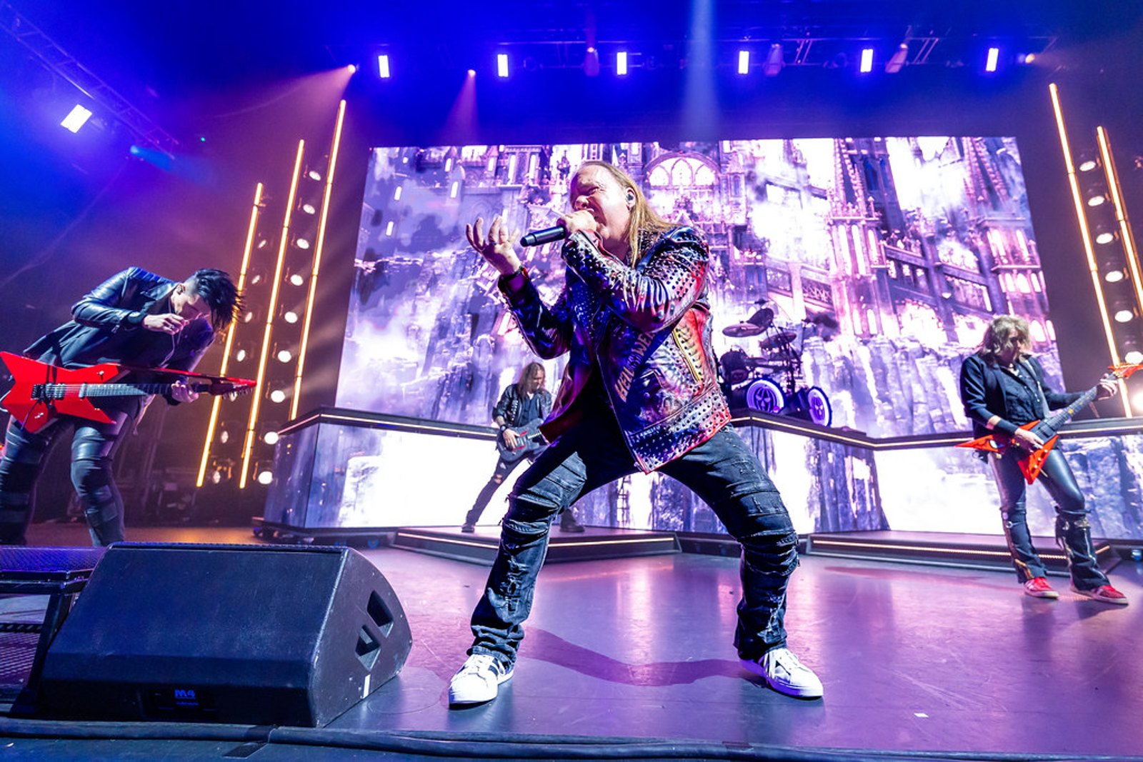 Michael Kiske singing centre stage with Helloween live, backed by a castle-themed video screen