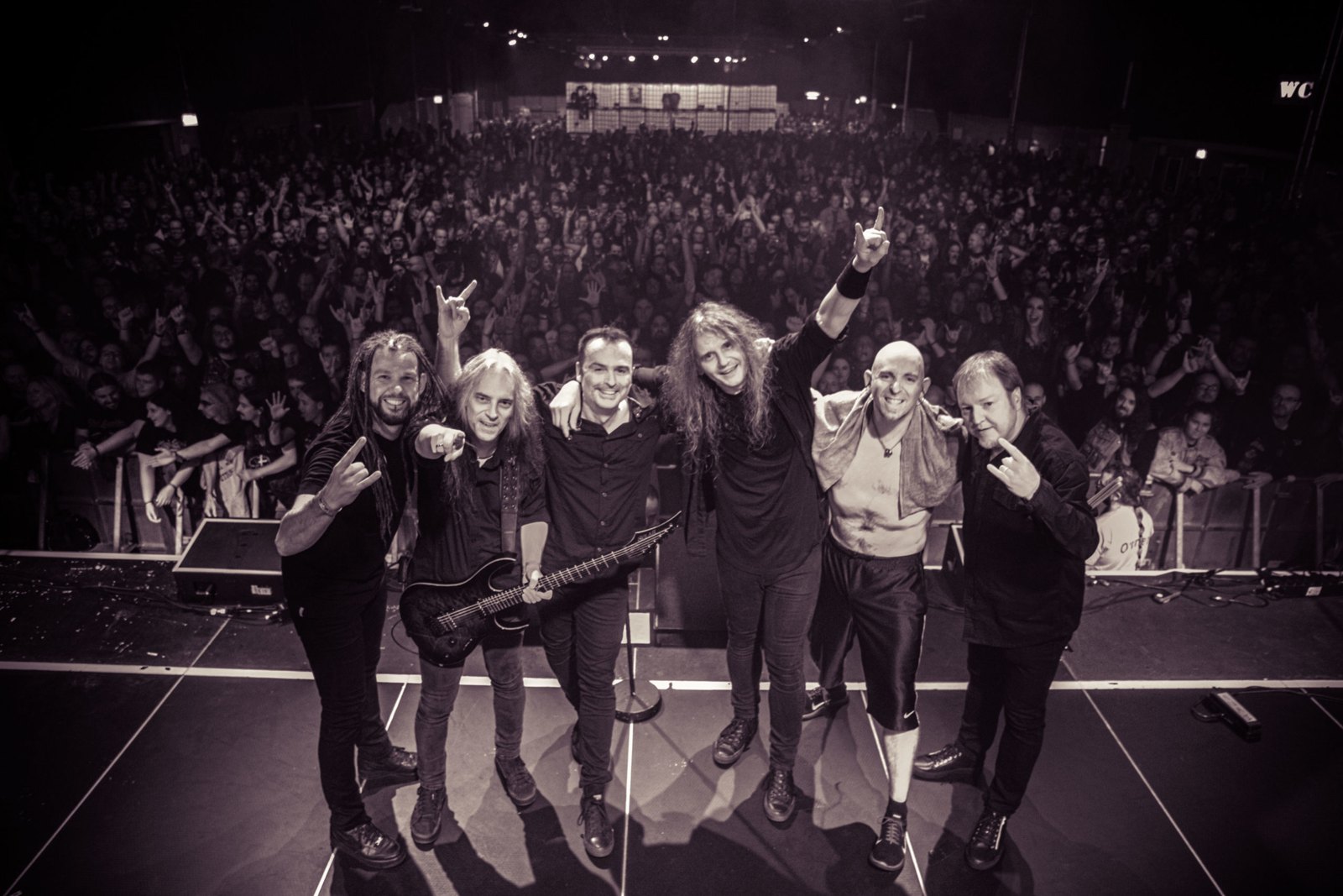 Blind Guardian posing together on stage at the end of their set, facing a packed crowd, Keep It True Festival, 20 November 2021.