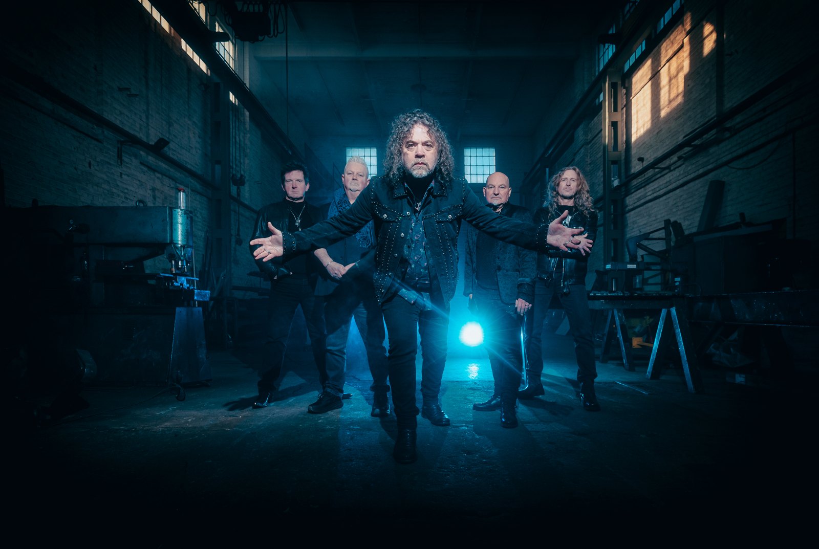 Tygers of Pan Tang posed as a five-piece in a disused industrial building, 2026