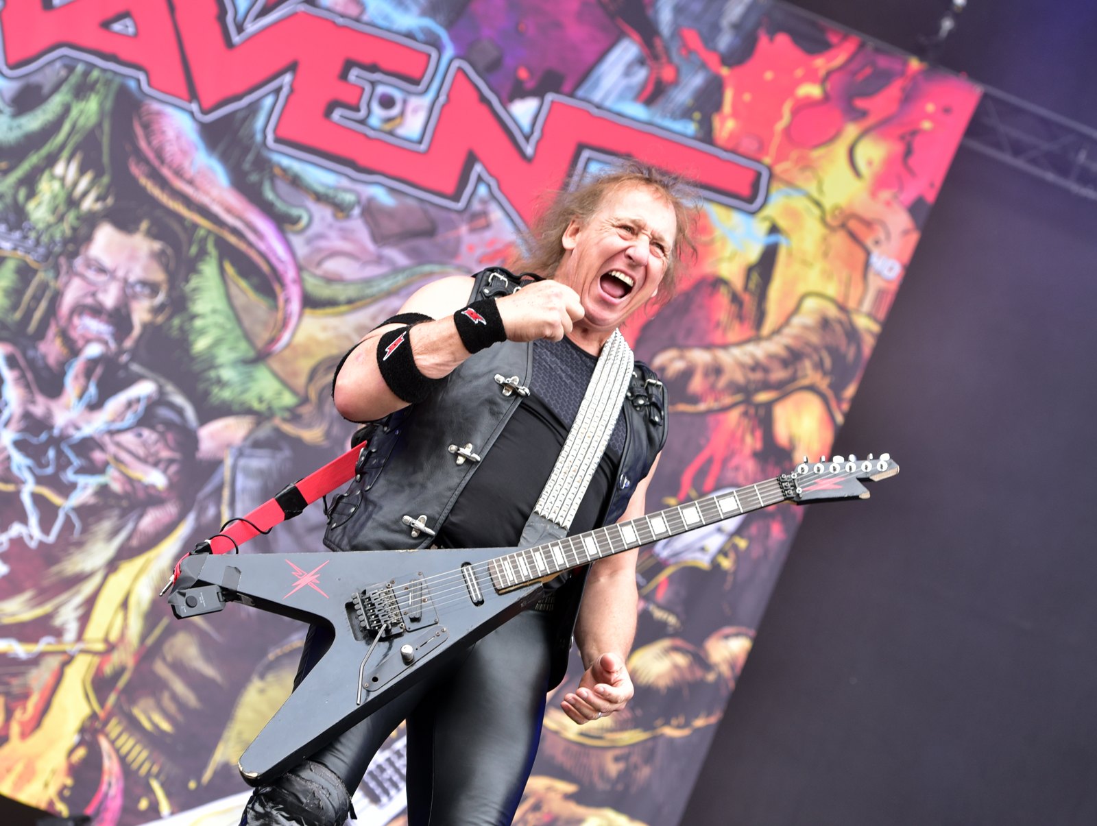 Mark Gallagher of Raven playing a Flying V on stage at Wacken Open Air in August 2024