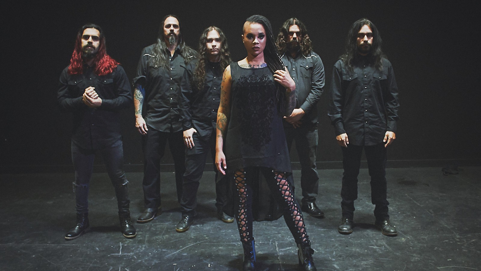 The six members of Oceans of Slumber on a dark bare stage, singer Cammie Beverly standing at the front