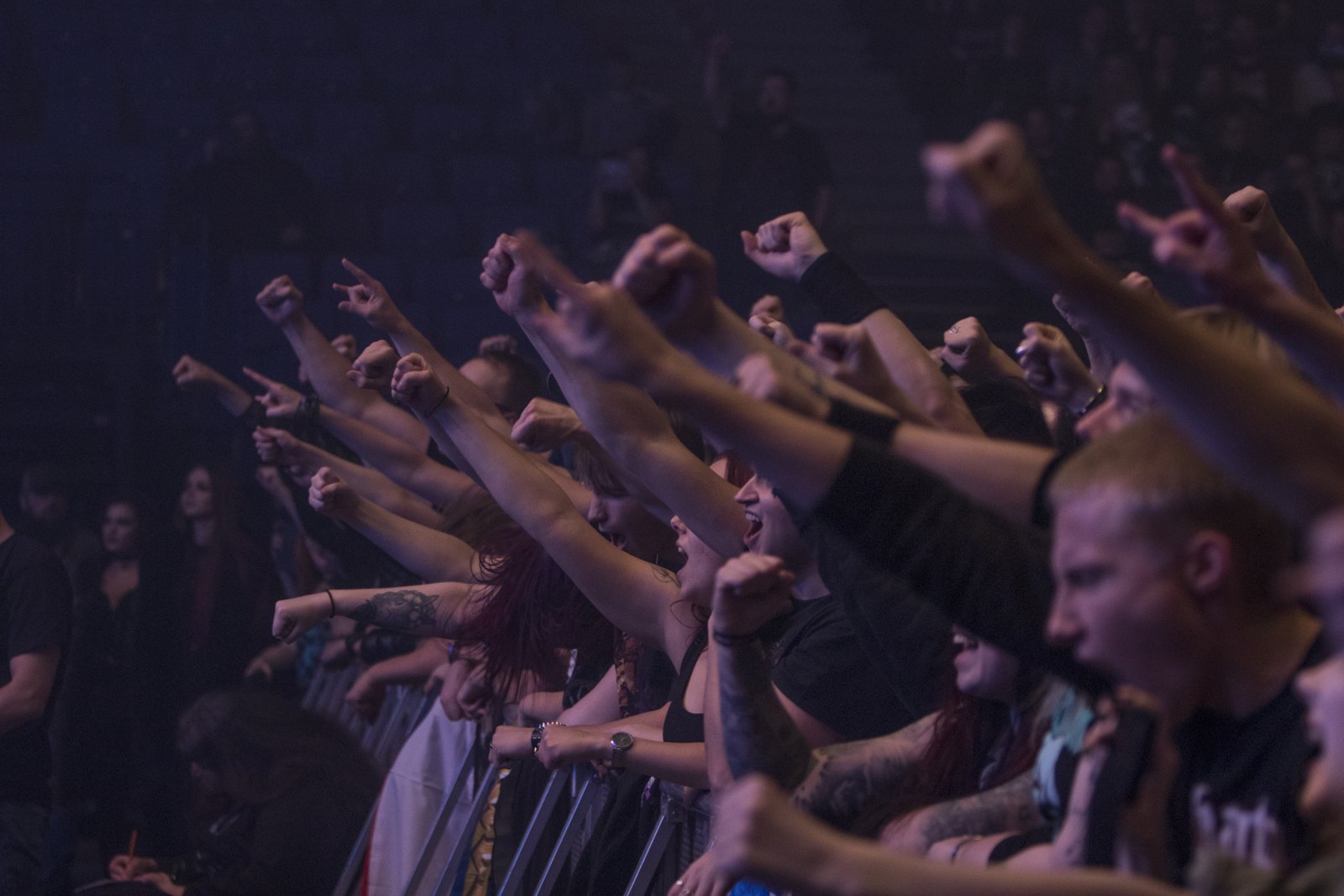 A crowd pressed to the barrier with fists and horns raised at a metal show in Helsinki in November 2019